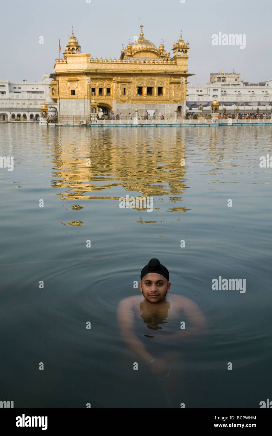 Homme Sikh se baigne dans les eaux - l'Sarovar (réservoir d'eau) -autour du Temple d'Or (Sri Harmandir Sahib) Amritsar. Punjab. L'Inde Banque D'Images