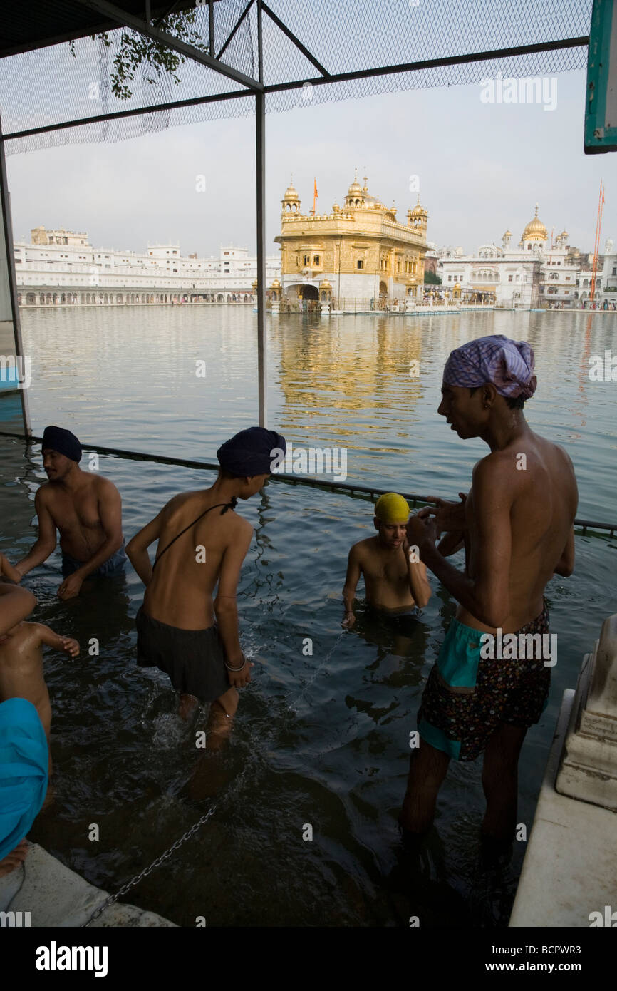 Les hommes sikhs se baignent dans les eaux - l'Sarovar (réservoir d'eau) -autour du Temple d'Or (Sri Harmandir Sahib) Amritsar. Punjab. L'Inde Banque D'Images