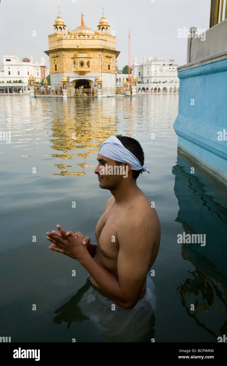 Homme Sikh se baigne dans les eaux - l'Sarovar (réservoir d'eau) -autour du Temple d'Or (Sri Harmandir Sahib) Amritsar. Punjab. L'Inde Banque D'Images