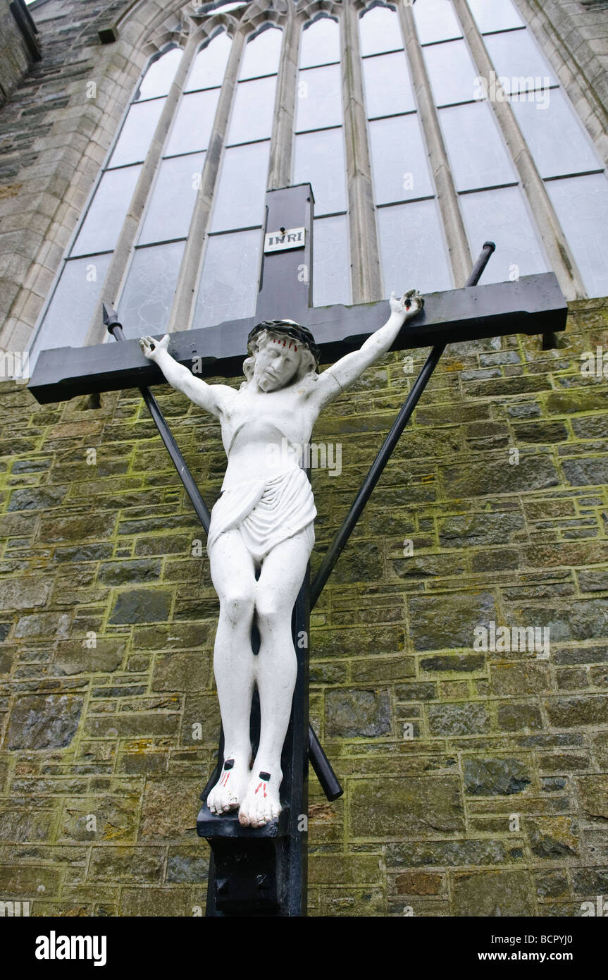 Crucifix contre un mur de l'église et fenêtre Banque D'Images