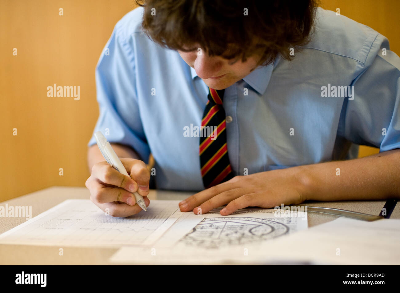 UK School England Grammar School Education. Un jeune étudiant écrit Banque D'Images