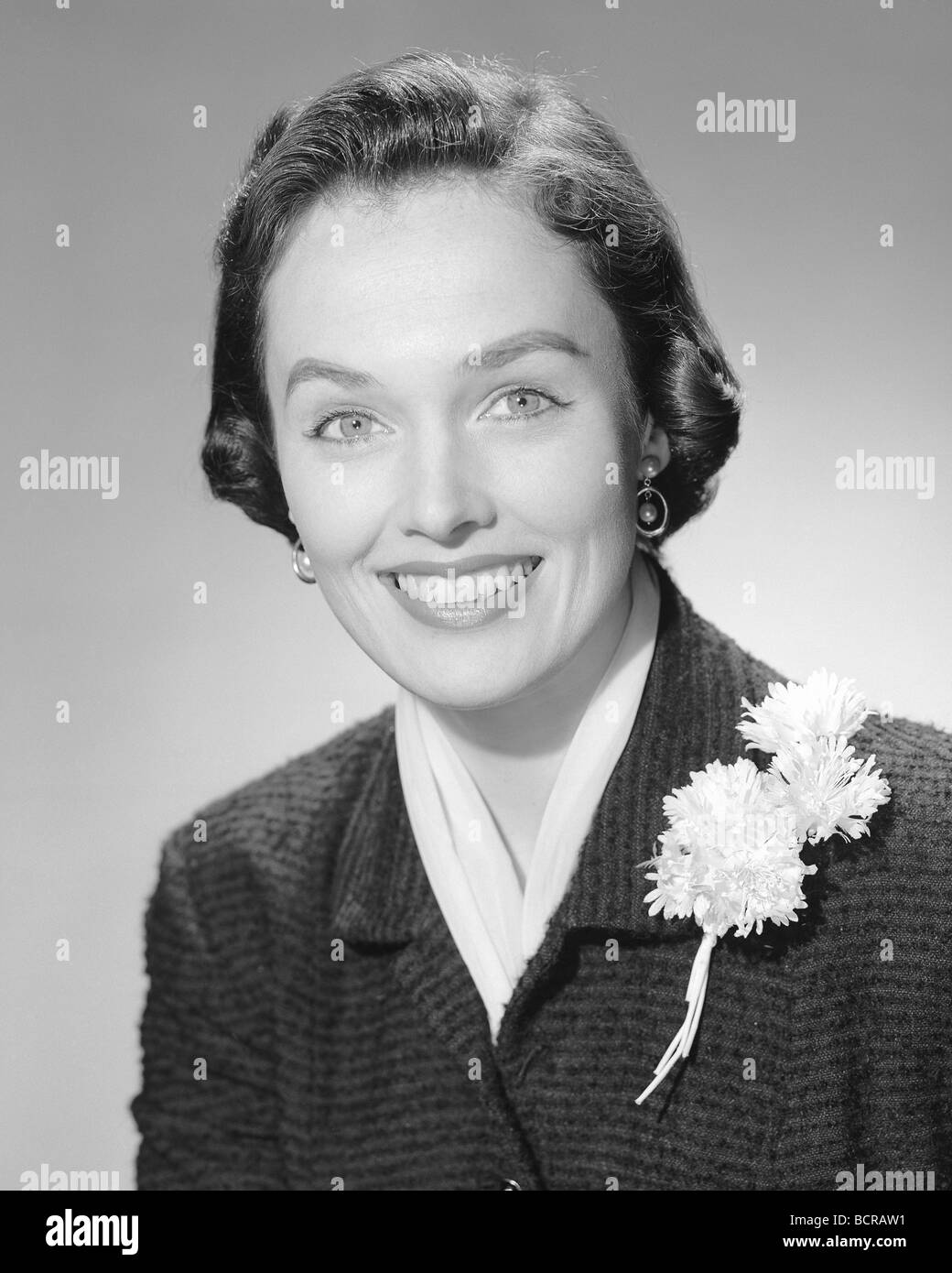 Portrait of young woman smiling, studio shot Banque D'Images