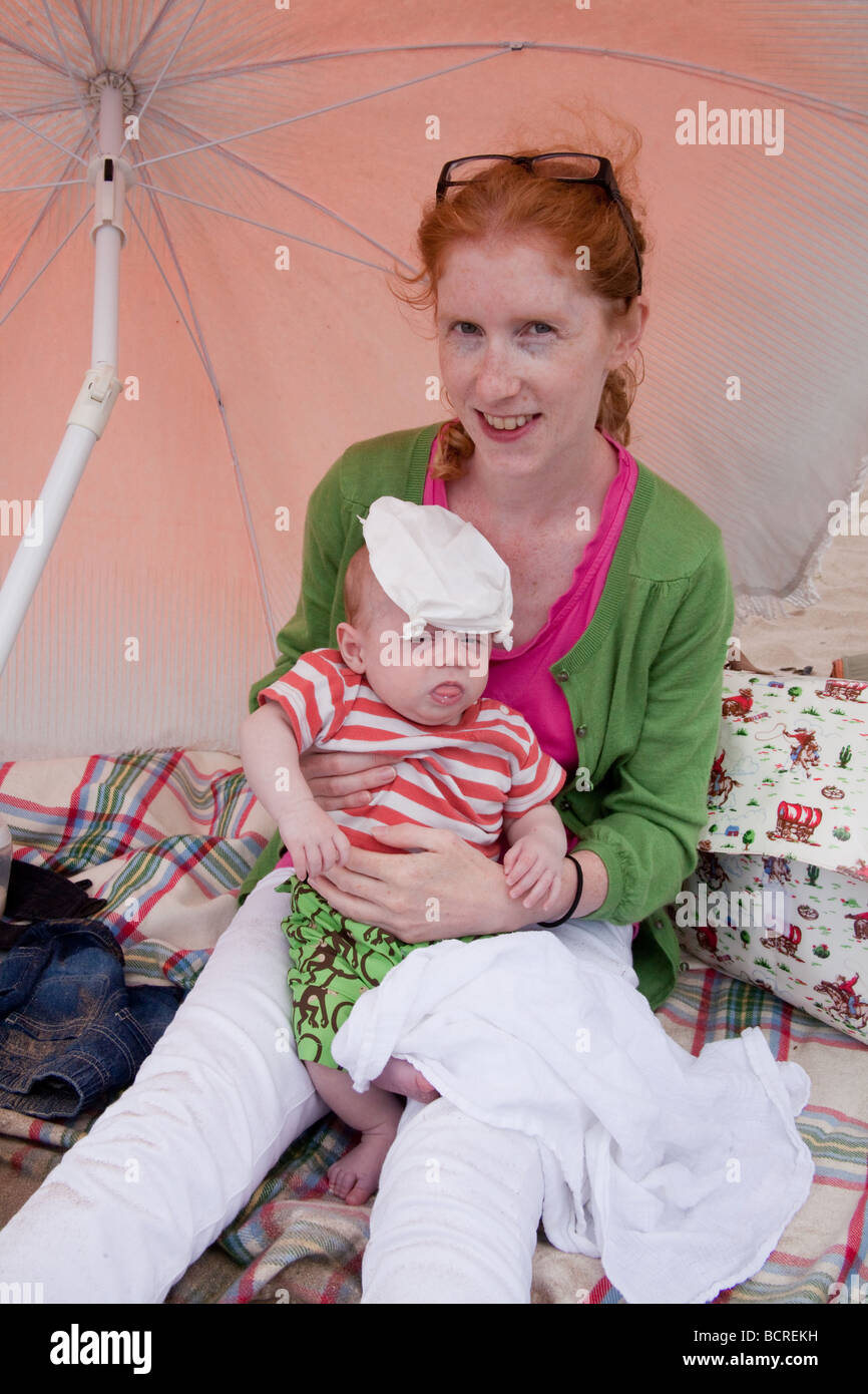 Mere Et 2 Mois Bebe Garcon Sur La Plage Sous Un Parasol Devon Angleterre Photo Stock Alamy