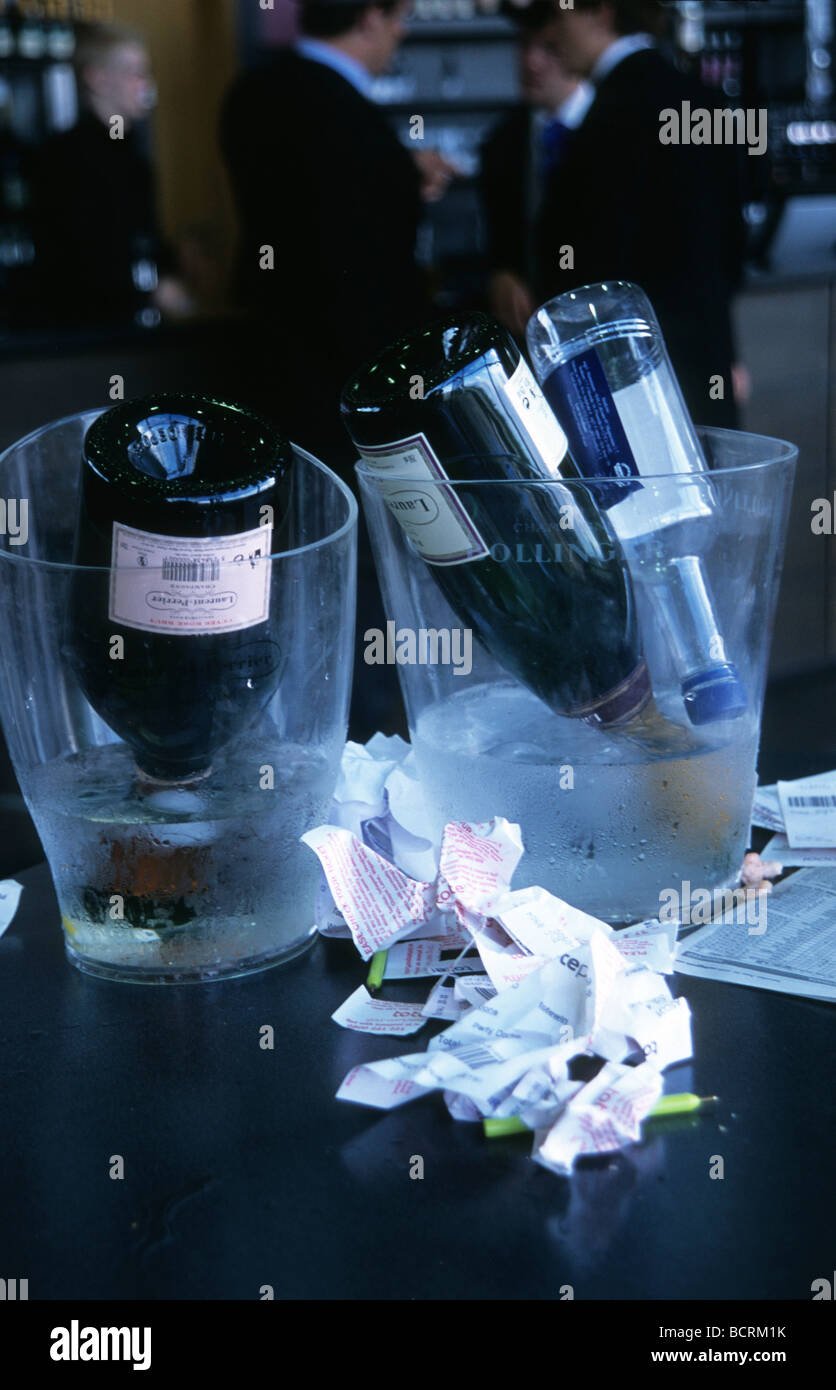 Des bouteilles de champagne vides et feuillets de pari chiffonné dans un bar à Ascot's Royal Enclosure. Banque D'Images