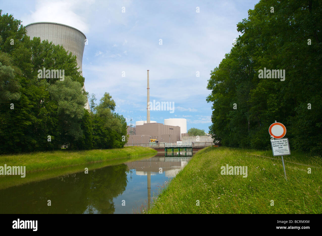 Canal d'amenée d'eau de refroidissement à la centrale nucléaire de Gundremmingen en Allemagne. Signe : les piétons et les cyclistes peuvent utiliser ce chemin dans leur propre risque. Banque D'Images