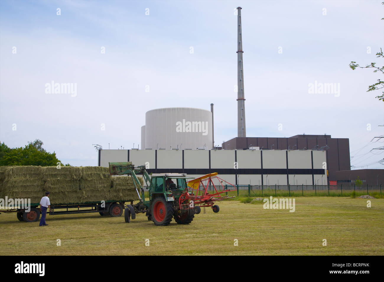 Le travail agricole à l'avant du hall de stockage du combustible nucléaire à la centrale nucléaire de Gundremmingen en Bavière, Allemagne. Banque D'Images