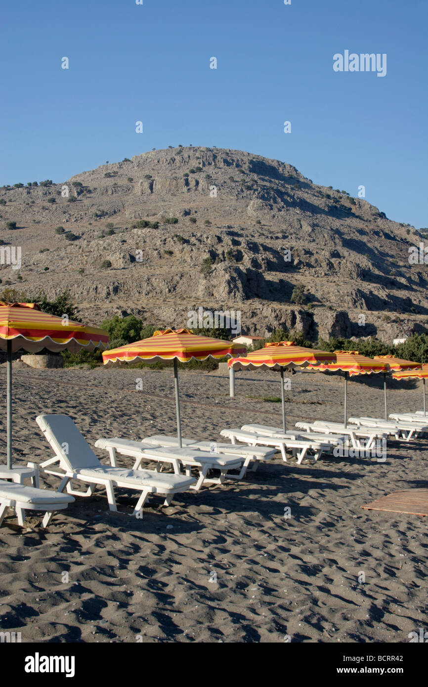 Transats et parasols sur la plage de sable de Lothiarika près de Lardos Grèce / Îles du Dodécanèse / Rhodes Banque D'Images