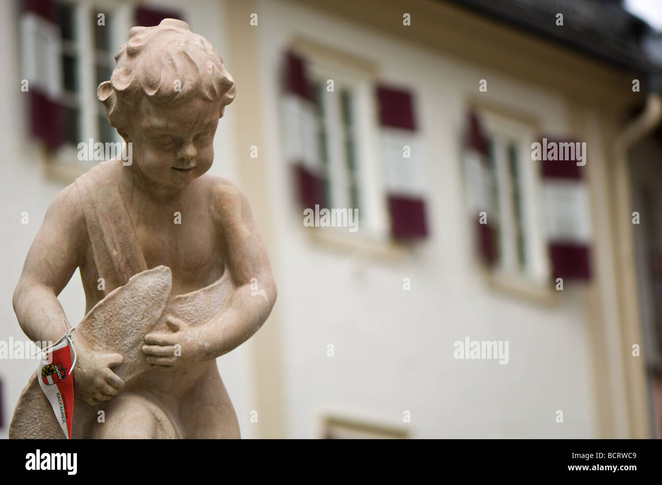 Statue de pierre d'un garçon et de poisson sur la place de la ville de Zell am See en Autriche. Banque D'Images