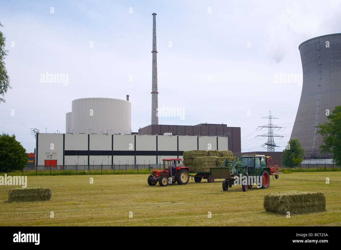 Le travail agricole à l'avant du hall de stockage du combustible nucléaire à la centrale nucléaire de Gundremmingen en Bavière, Allemagne. Banque D'Images