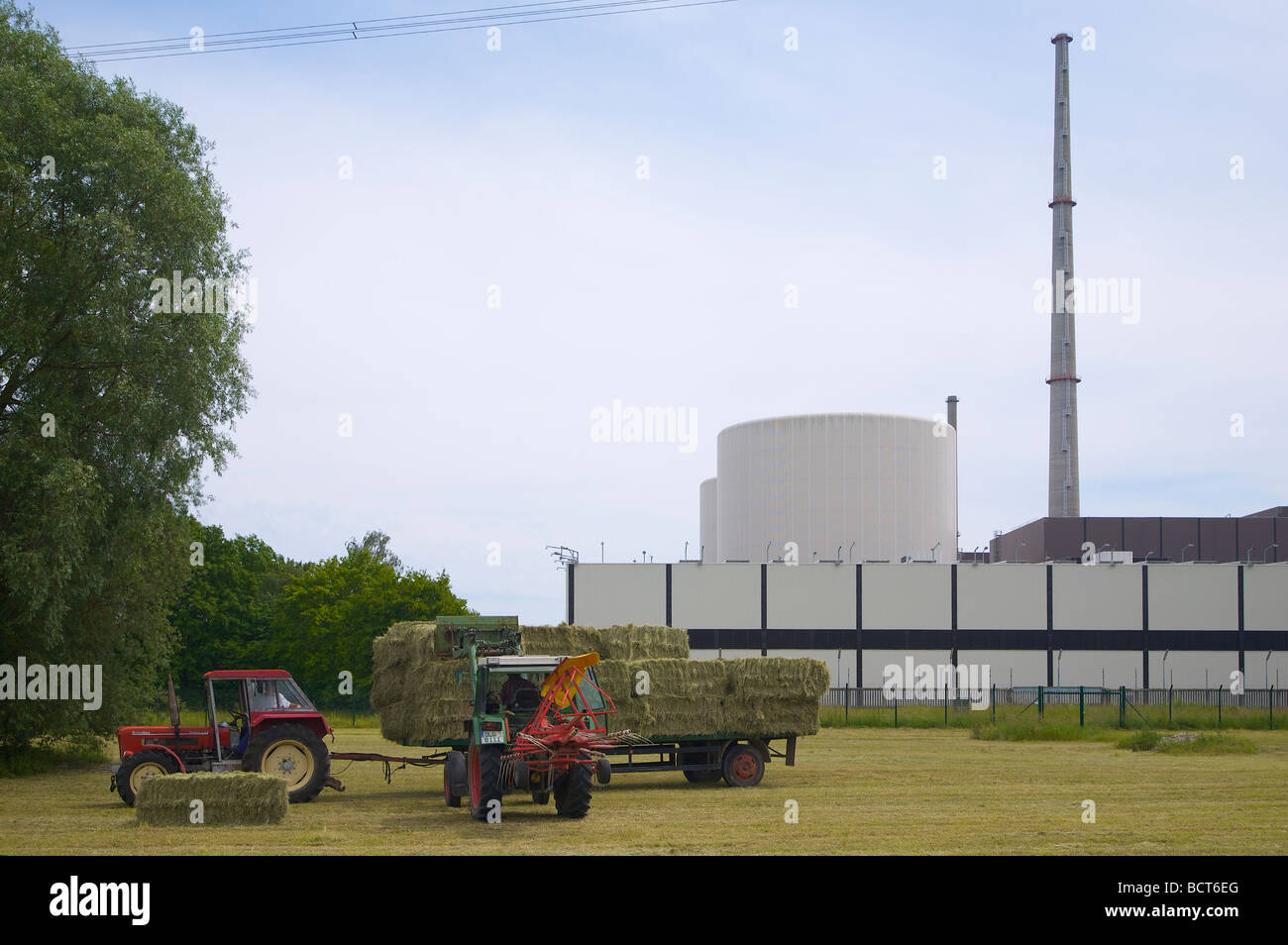 Le travail agricole à l'avant du hall de stockage du combustible nucléaire à la centrale nucléaire de Gundremmingen en Bavière, Allemagne. Banque D'Images