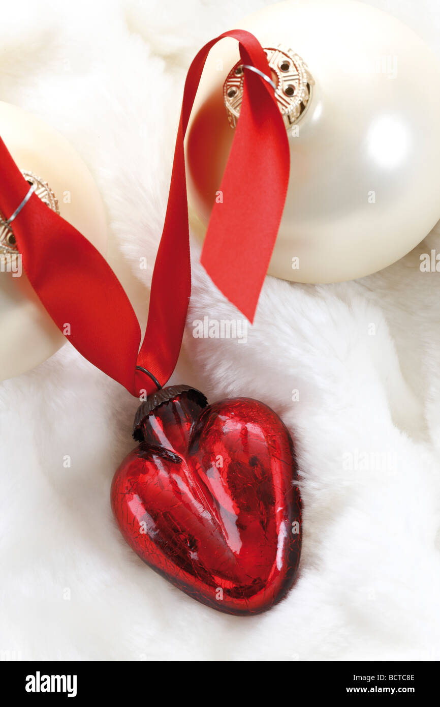 En forme de coeur rouge décoration de Noël et boule de noël sur couverture de fourrure Banque D'Images