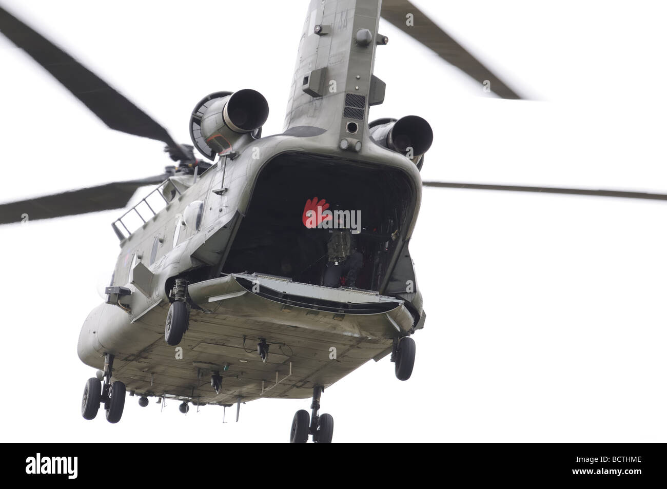 L'arrimeur Boeing Chinook agite sa grosse main rouge de l'arrière de son hélicoptère en vol stationnaire à la 2009 RAF Fairford Banque D'Images