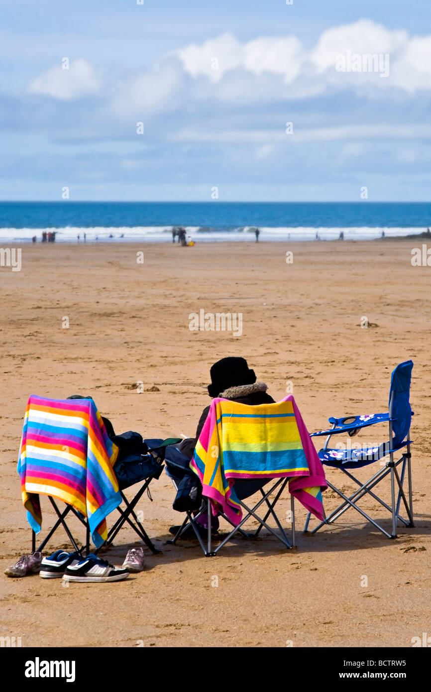 Personne âgée, assis sur chaise de camping, lecture, sur la plage Pavillon Bleu de Woolacombe Sands désignés dans le Nord du Devon Banque D'Images