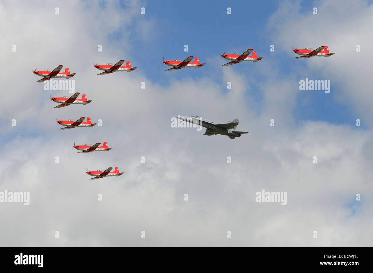 La Swiss Air Force l'équipe de démonstration de la voltige dans leurs prop powered Pilatus formateurs en formation avec un F-18 Hornet jet Banque D'Images