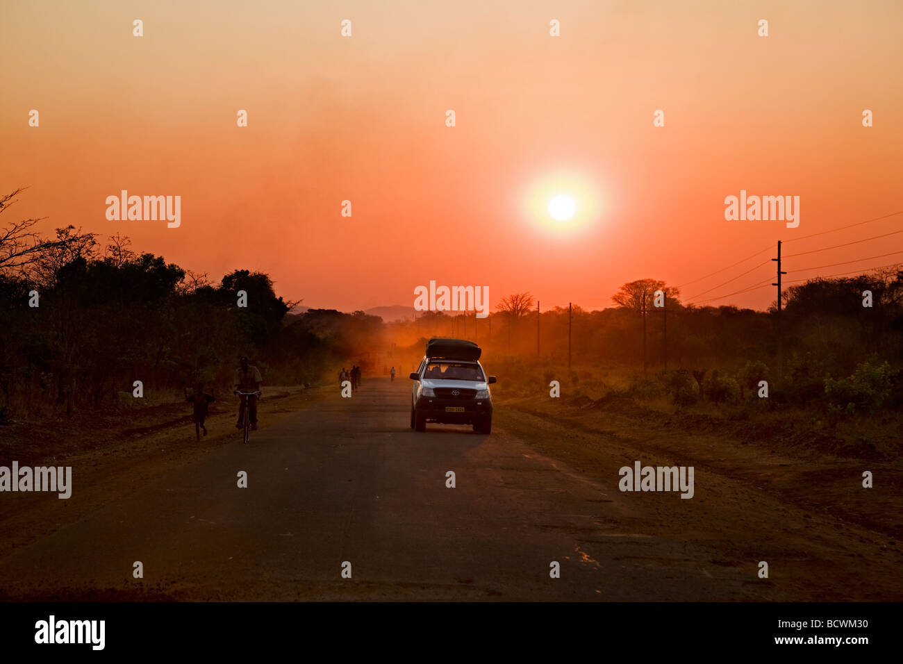 Coucher du soleil avec voiture sur la route, la Zambie, l'Afrique Banque D'Images
