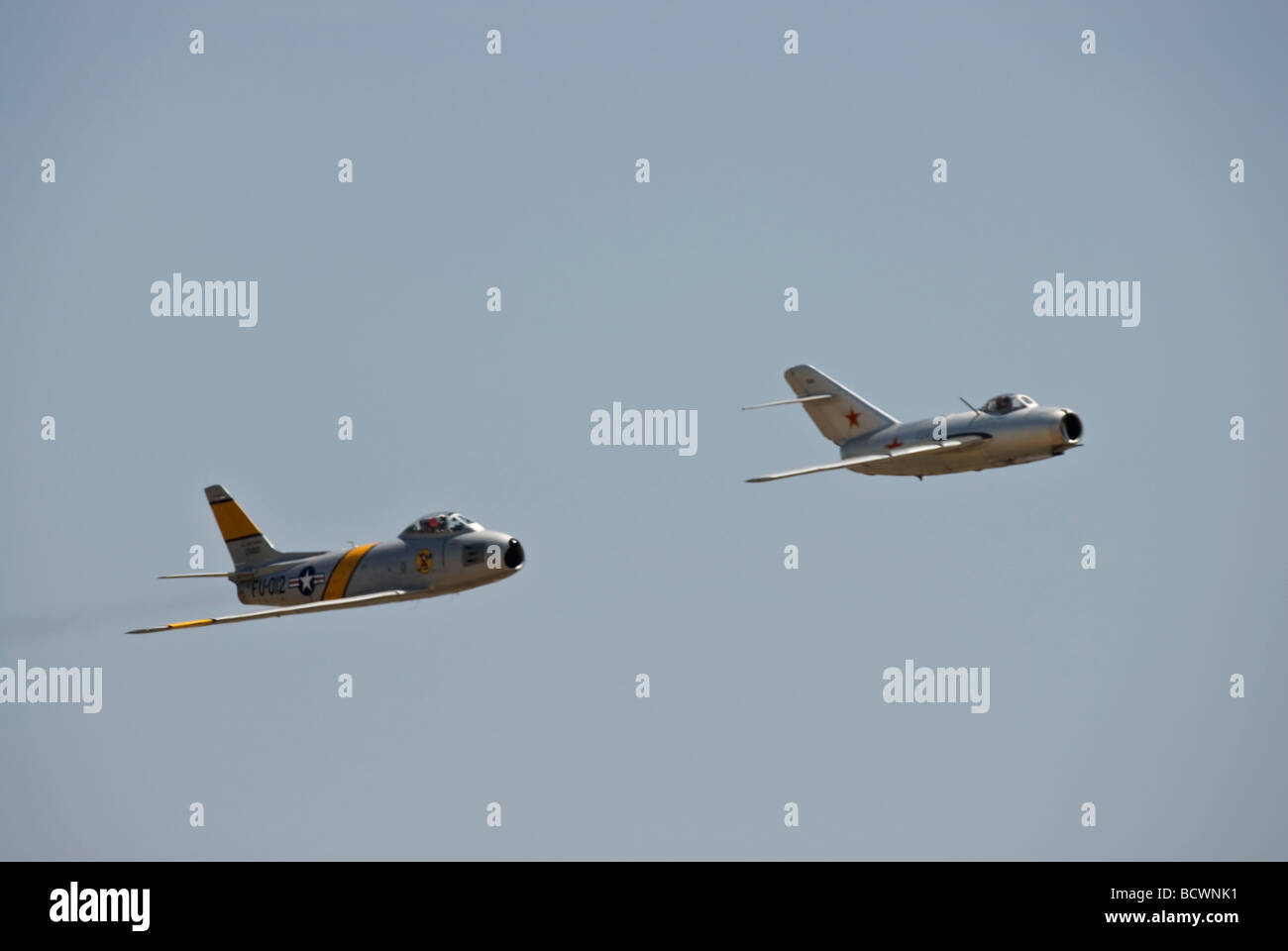 Un MiG-15 est suivie de près à une reconstitution de combat à un meeting aérien. Banque D'Images