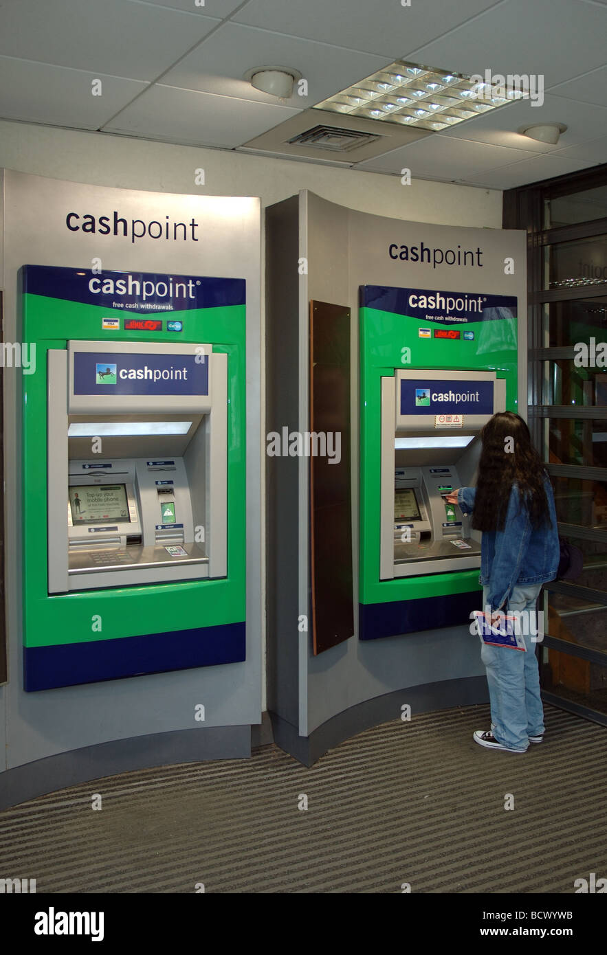 Femme à l'aide de la Lloyds TSB Bank distributeur, Christchurch, Dorset, England, UK Banque D'Images
