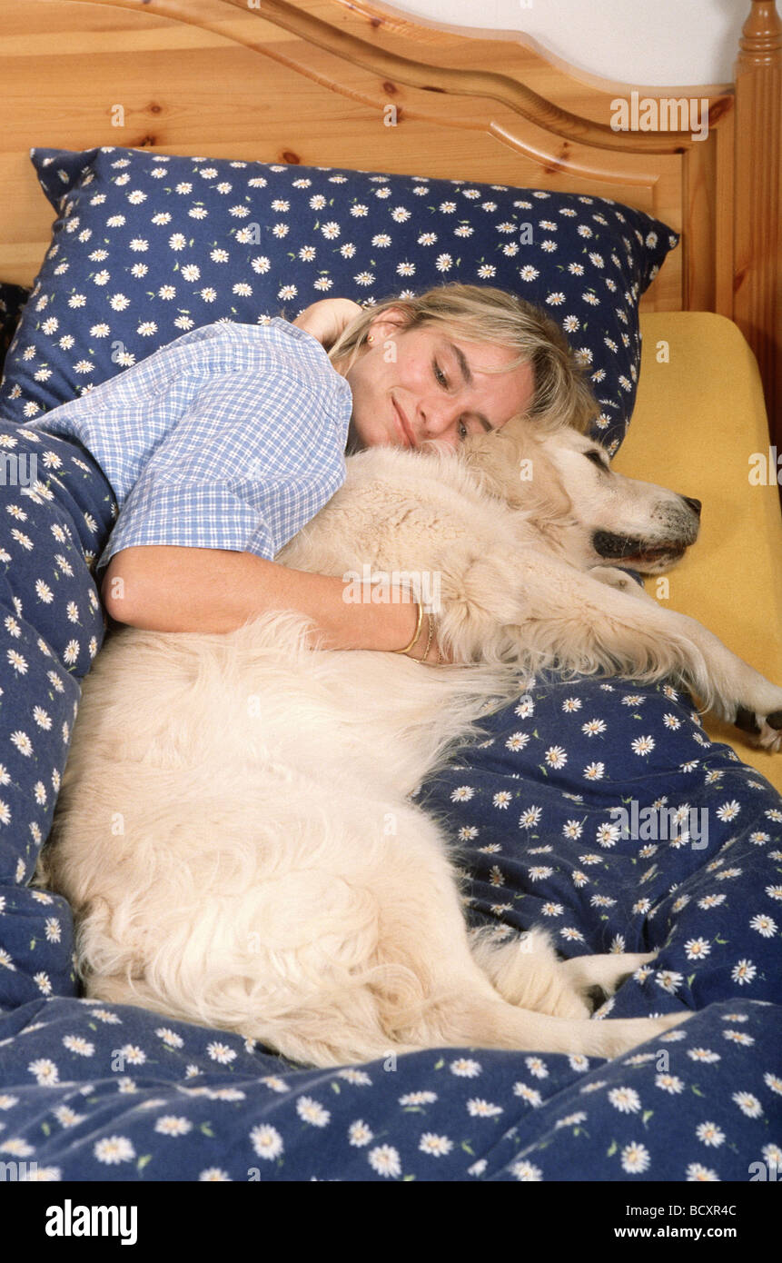 Chien et femme au lit Banque D'Images