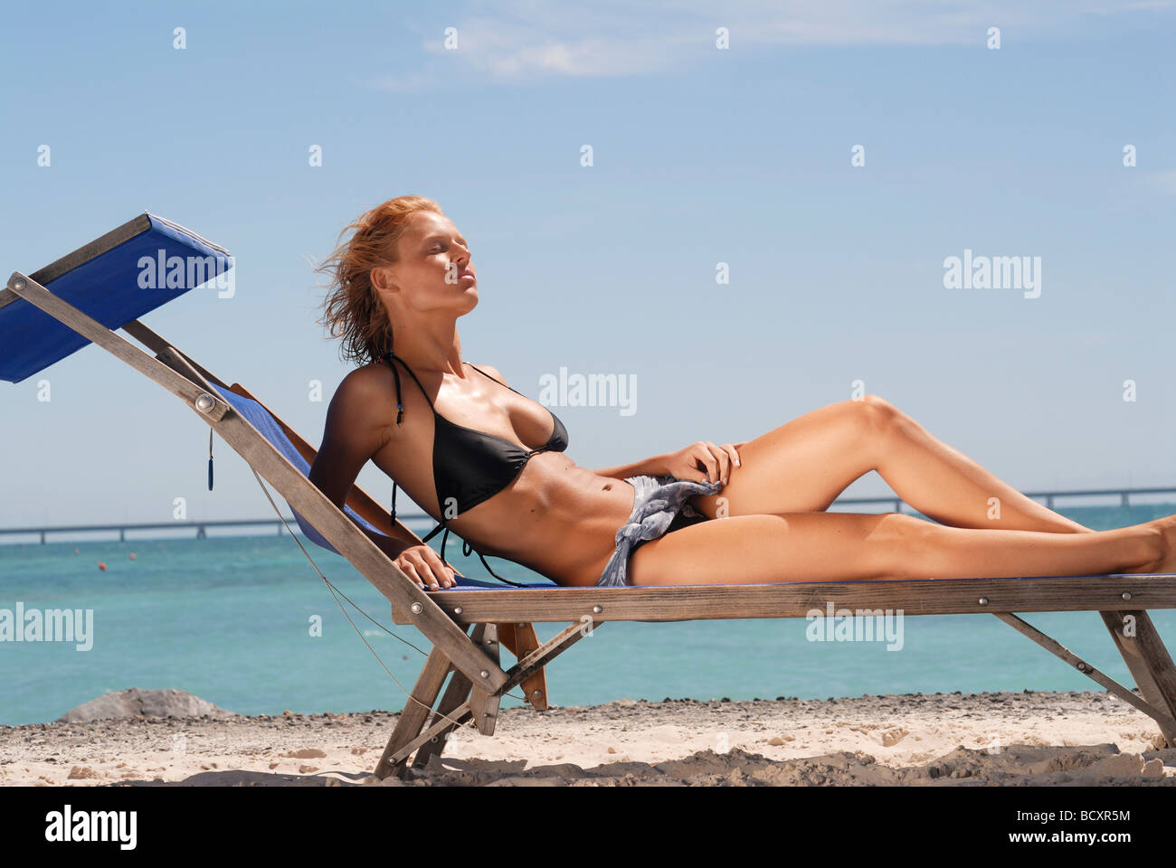 Jeune femme en train de bronzer sur la plage Photo Stock - Alamy