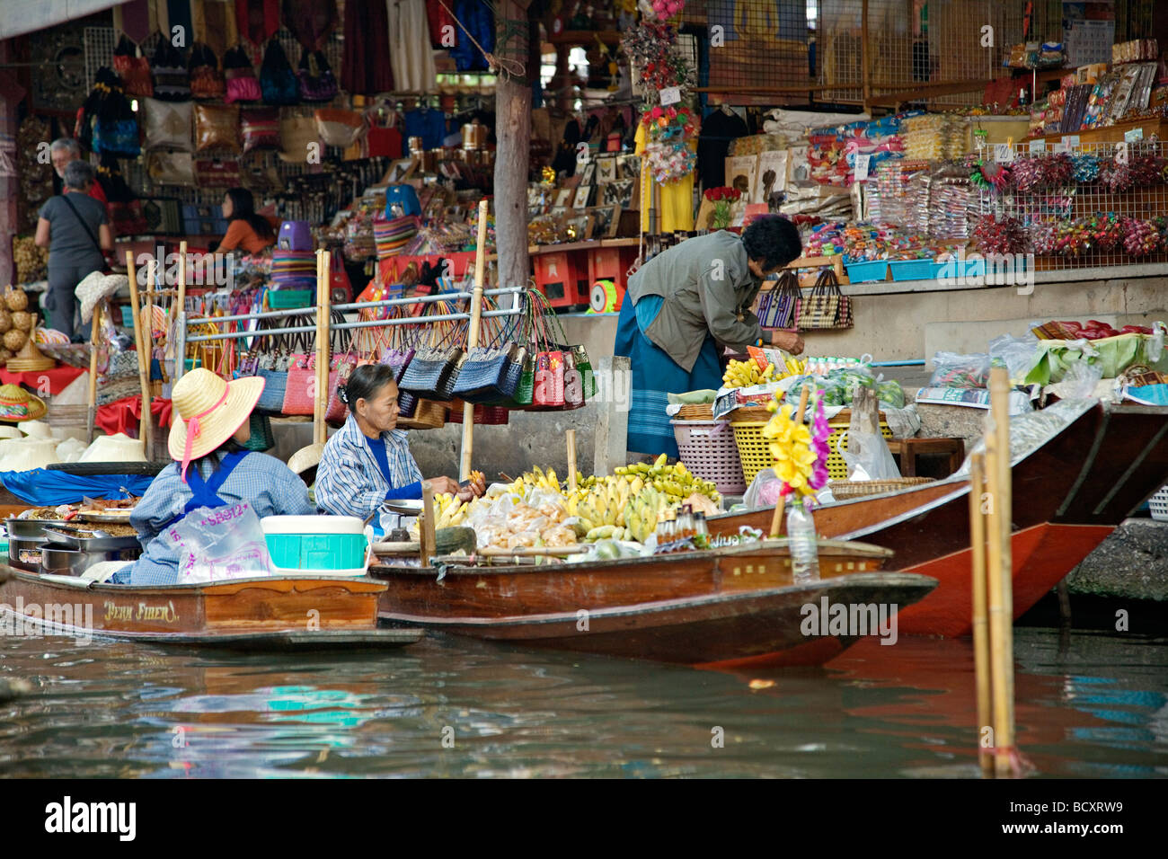 Vente d'aliments et de souvenirs à la marché flottant de Damnoen Saduak situé à environ 62 milles à l'extérieur de Bangkok Thaïlande Banque D'Images