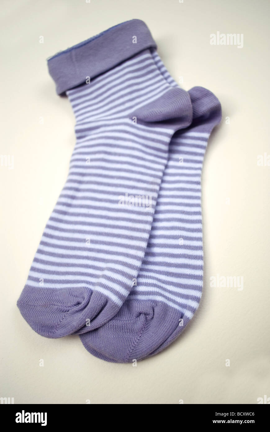 Une paire de chaussettes à rayures violet et blanc. Banque D'Images