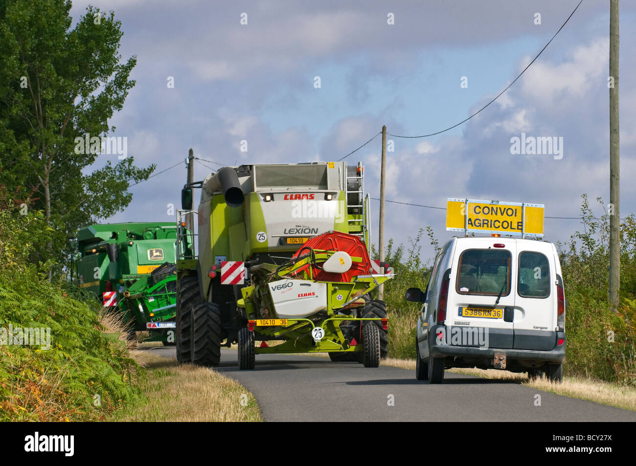 Moissonneuse-batteuse John Deere Claas et exploitants en convoi de bloquer la voie publique, sud-Touraine, France. Banque D'Images