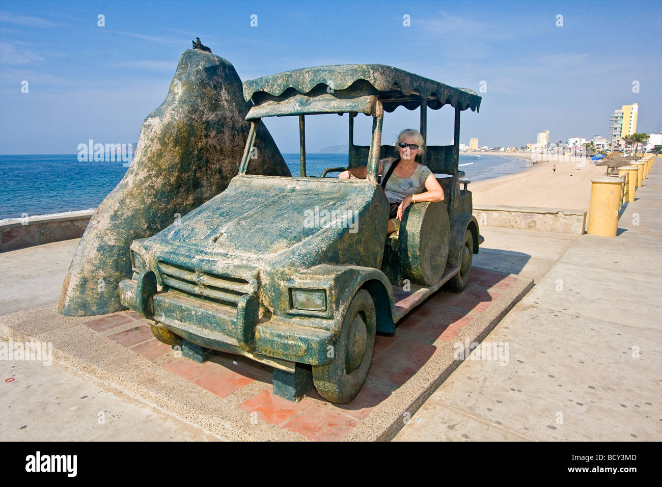 Femme assise dans une statue d'un pulmonia, un petit kart propulsé par Volkswagen Bug moteur, sur l'affichage le long du Malecon, Mazatlan Banque D'Images