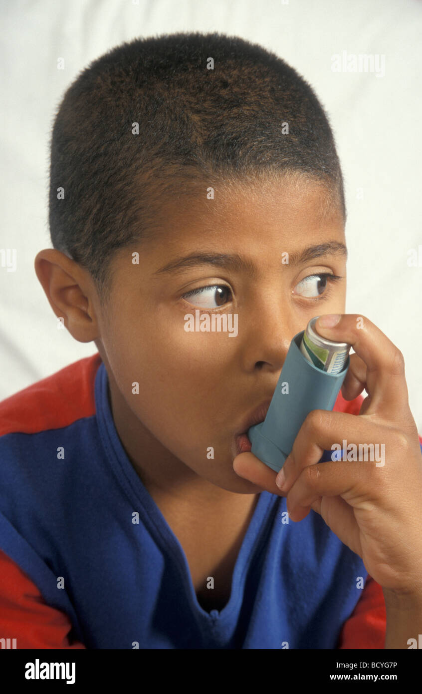 Jeune garçon noir à l'aide d'inhalateur de salbutamol pour l'asthme Banque D'Images