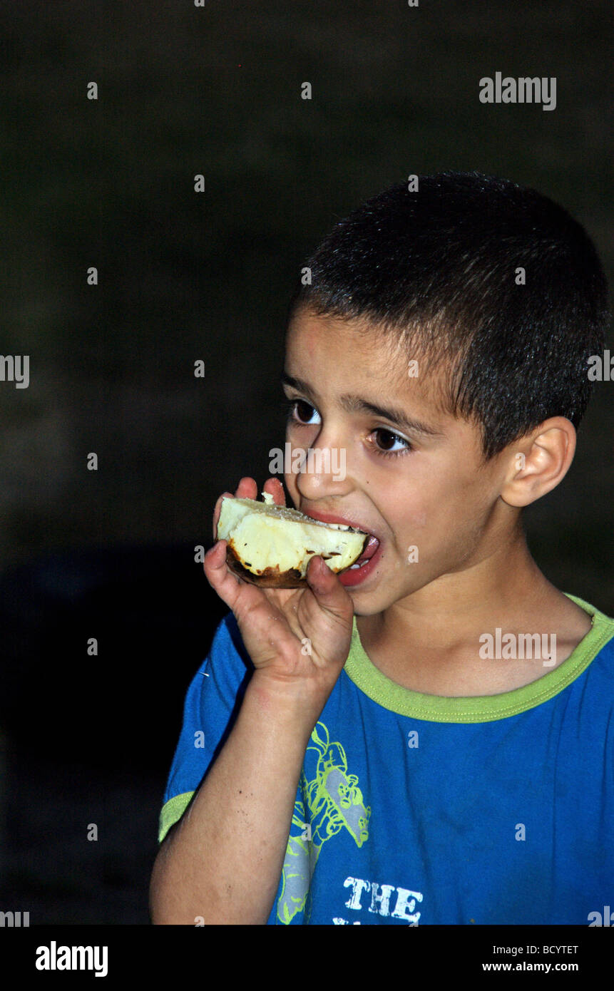 Israël Kibboutz Ashdot Yaacov Jordan Valley Lag Ba Omer célébration avec un feu enfant mangeant une pomme de terre au four de l'incendie Banque D'Images