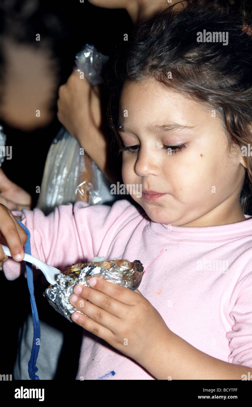Israël Kibboutz Ashdot Yaacov Jordan Valley Lag Ba Omer célébration avec un feu enfant mangeant une pomme de terre au four de l'incendie Banque D'Images