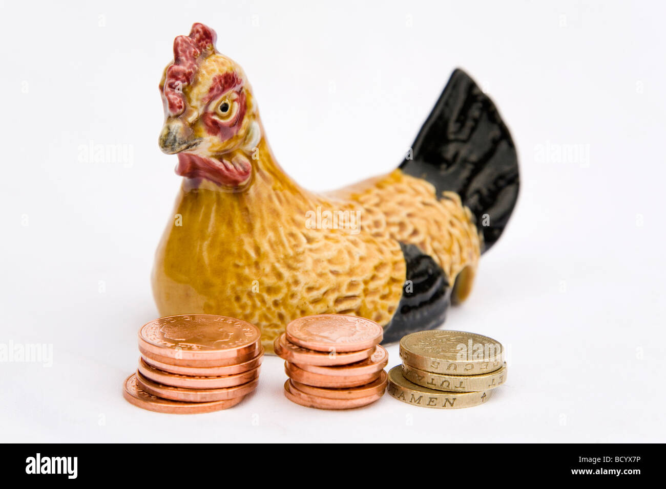 Des crédits sont mis à côté d'une poule en céramique. Une poule similaire a été utilisée pour la famille pour placer de l'argent dans la télévision britannique,pain série Banque D'Images