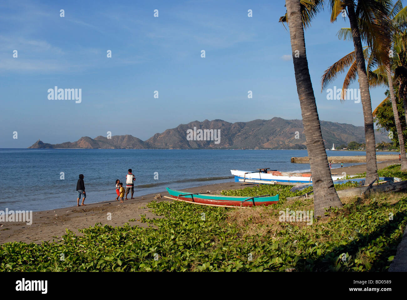 Une famille promenade le long de la plage de Dili, capitale du Timor Leste Banque D'Images