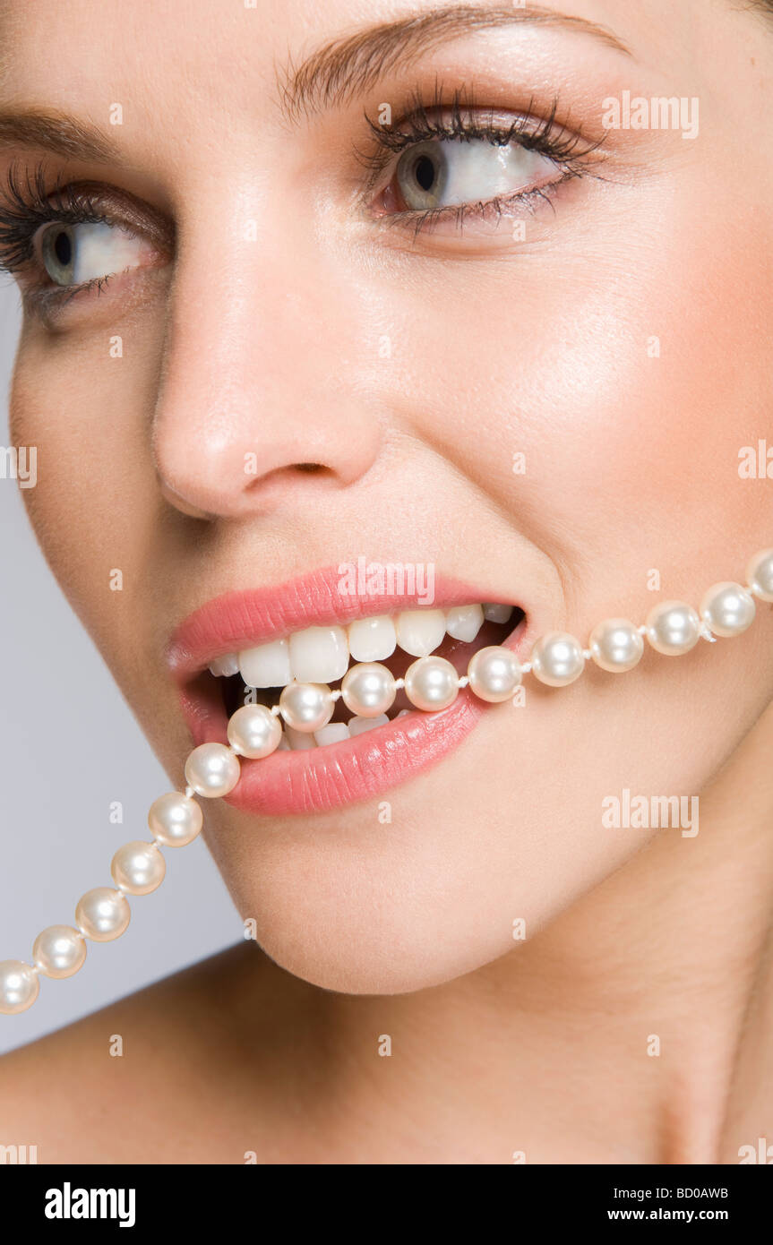 Modèle de beauté féminine avec des perles dans la bouche Banque D'Images