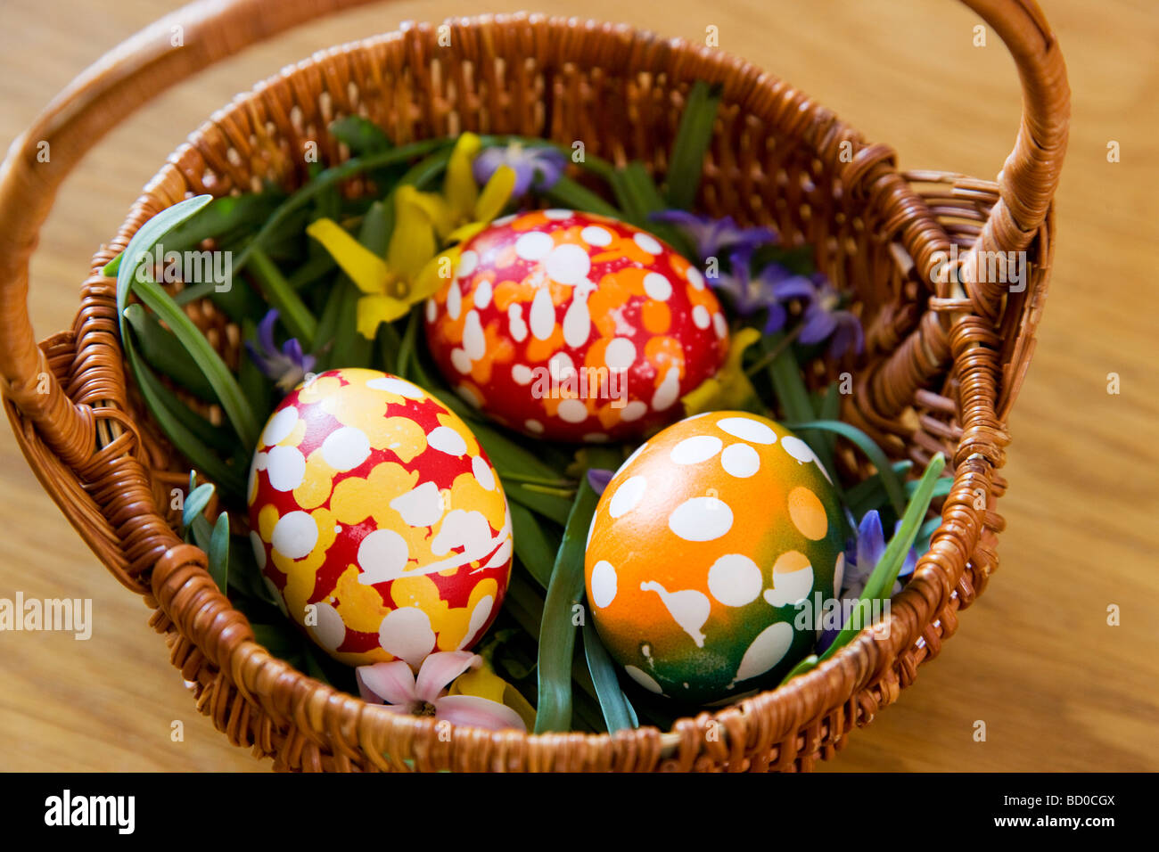 Les oeufs de Pâques peints dans panier Banque D'Images
