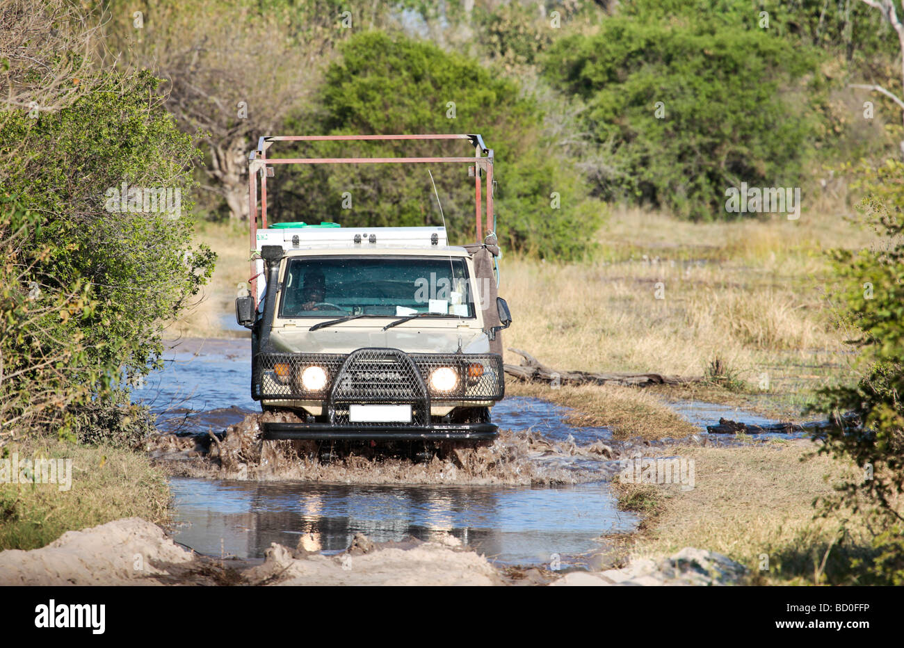 Safari véhicule d'assistance de la conduite dans une piste inondée dans le Delta de l'Okavango salon du Botswana Banque D'Images