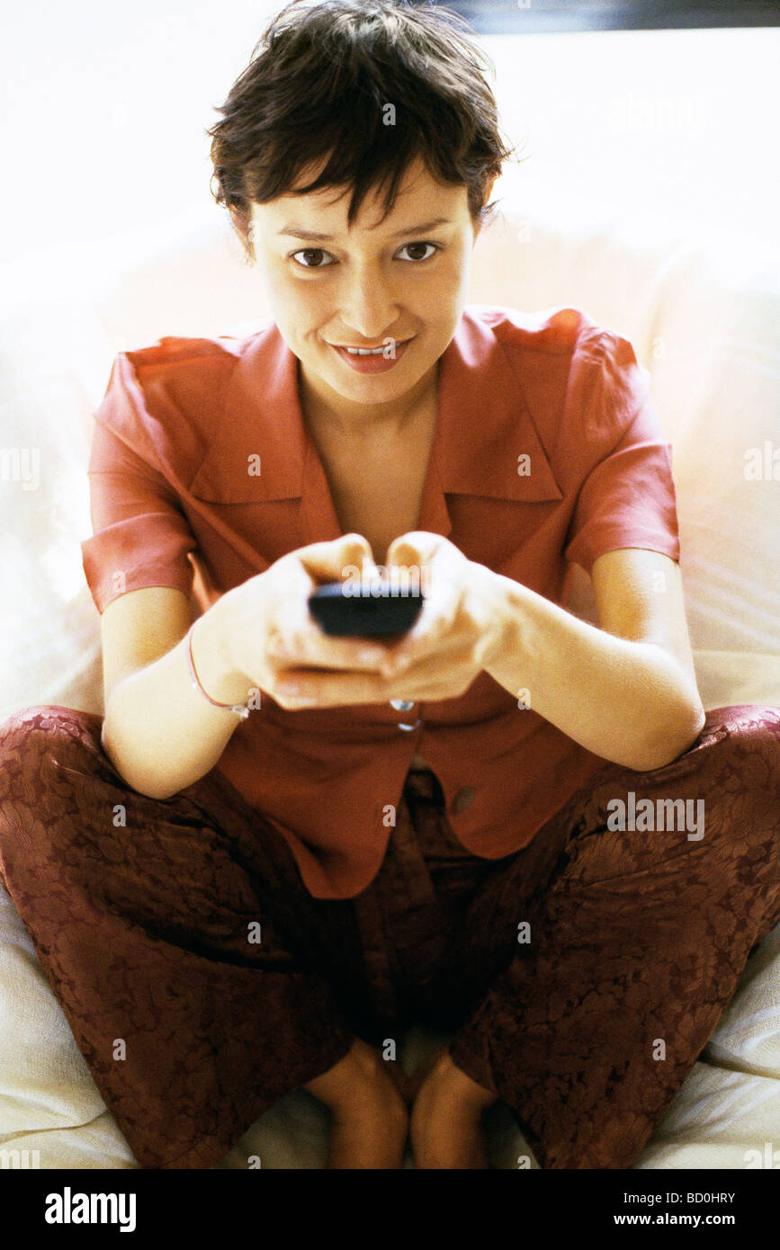 Femme regardant la TV, canal en évolution Banque D'Images