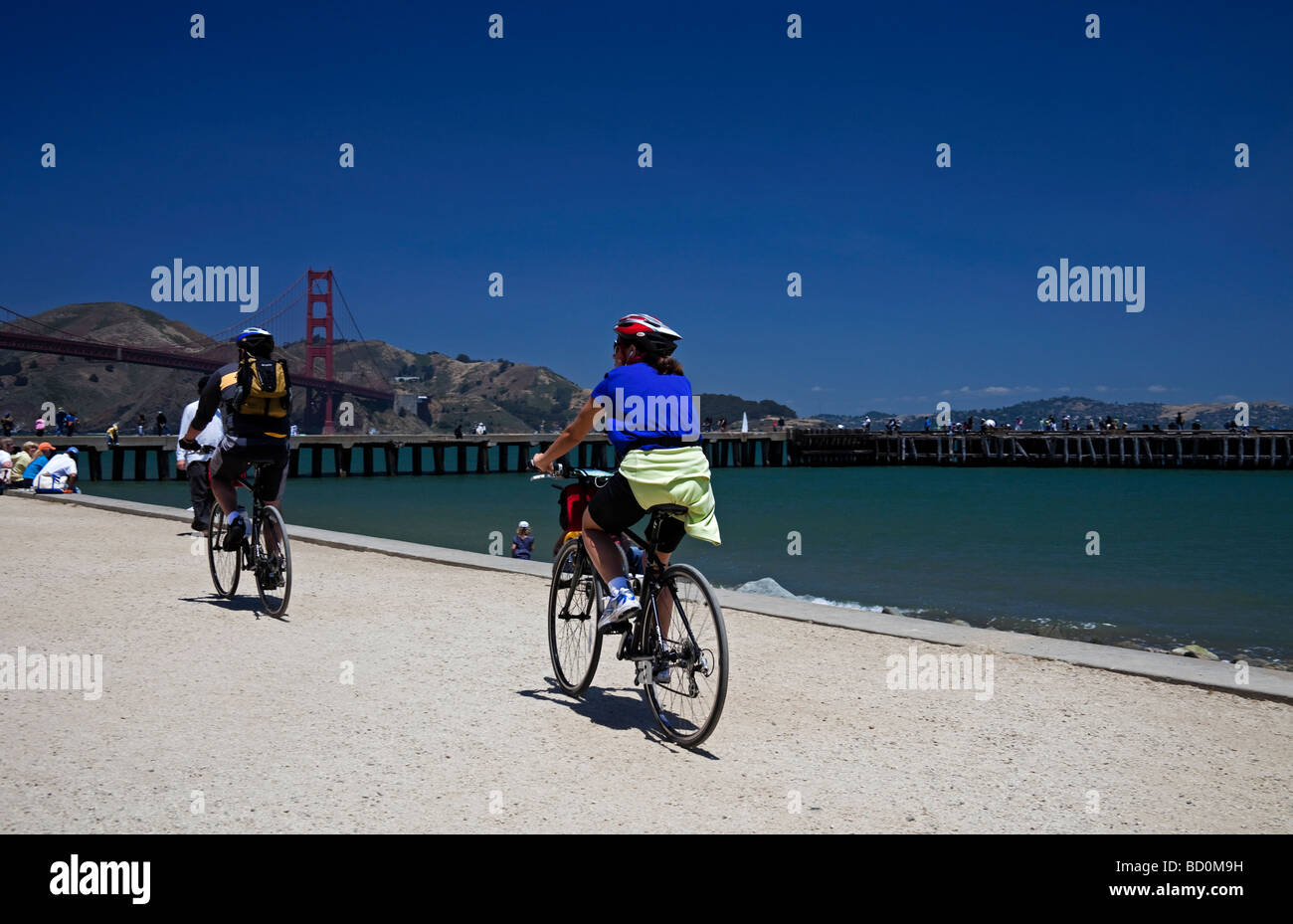 Les cyclistes du vélo le long du front de mer Terrain Crissy avec Golden Gate Bridge en arrière-plan de San Francisco, Californie, USA Banque D'Images