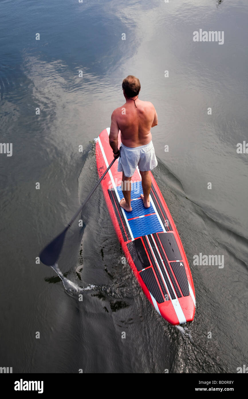 Aman sur un paddleboard standup, flotteurs les eaux fraîches de la rivière Deschutes dans le Old Mill District dans la région de Bend Oregon Banque D'Images