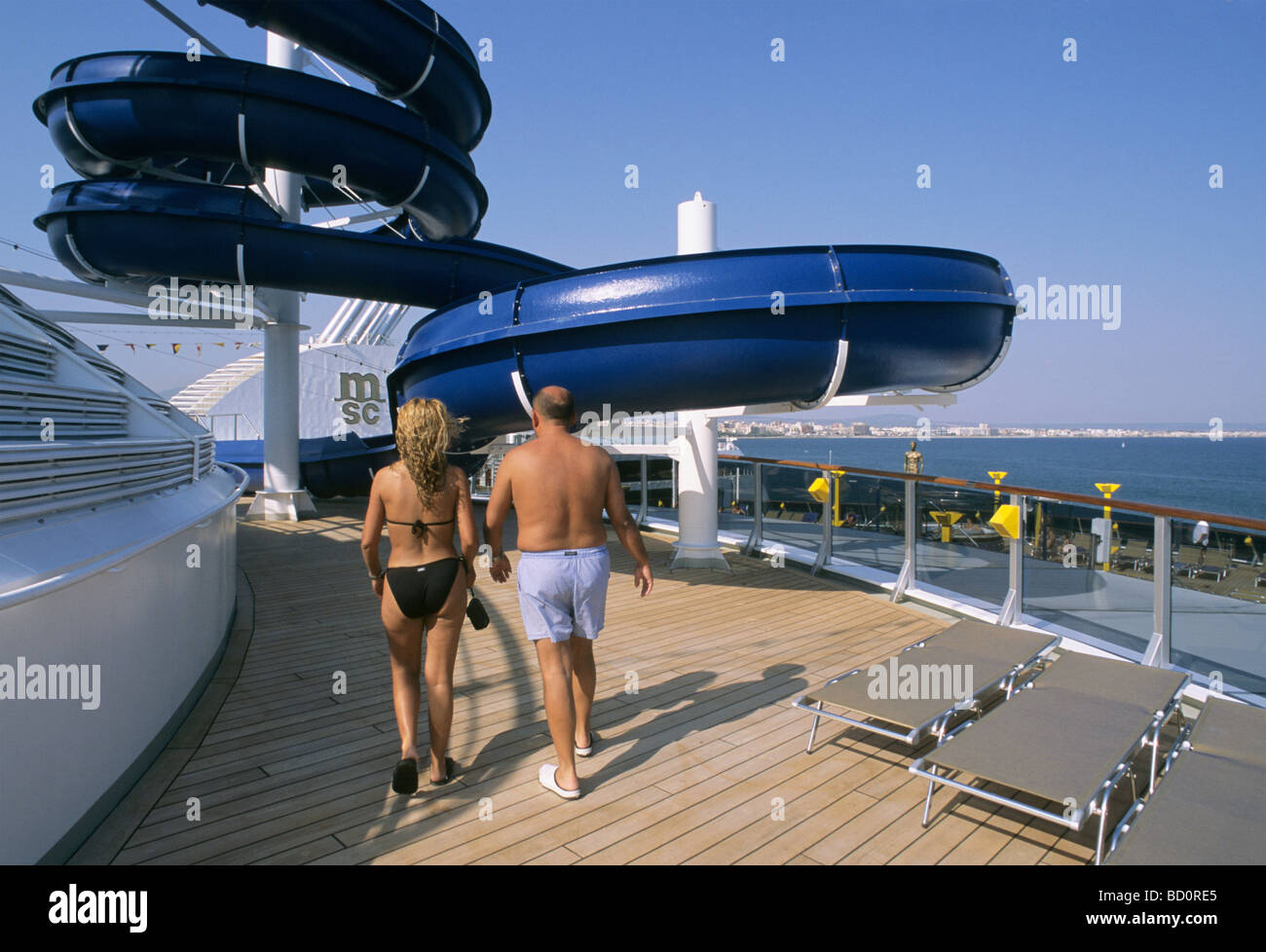 Un grand toboggan et deux passagers de marcher sur la terrasse d'un navire de croisière amarré dans le port de Palma de Majorque Banque D'Images
