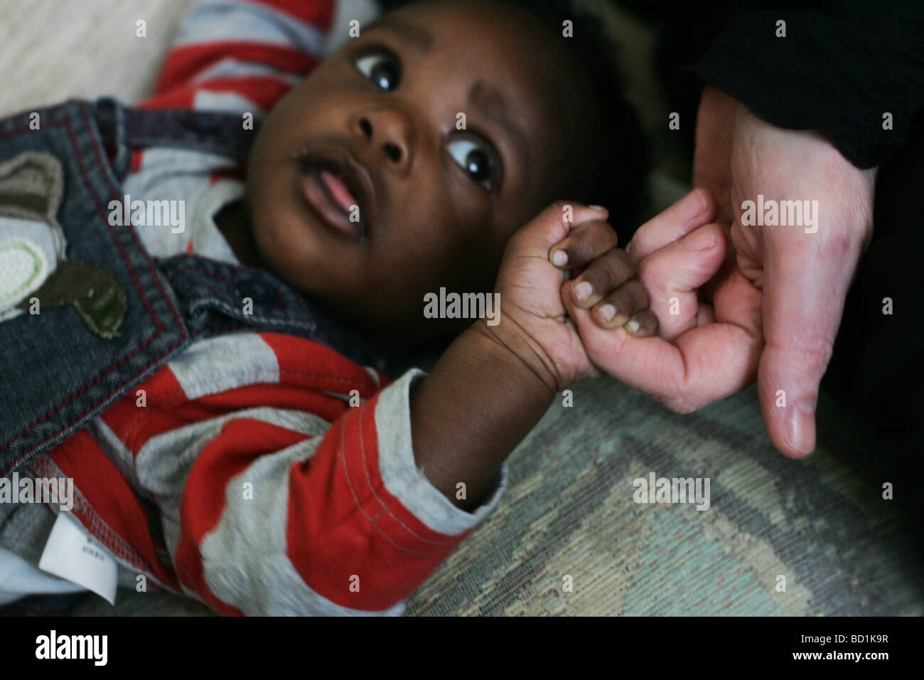 Un Bebe Noir Tenant Le Doigt D Une Femme Blanche Photo Stock Alamy
