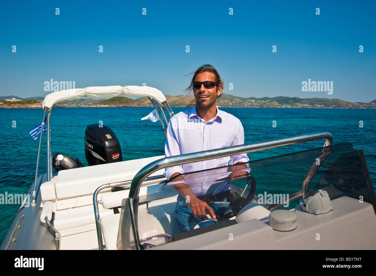 L'homme sur barre d'un bateau gonflable dans la mer Méditerranée en Grèce Banque D'Images