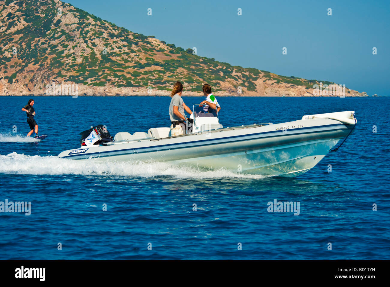 Fille sur un wakeboard derrière un bateau gonflable Banque D'Images