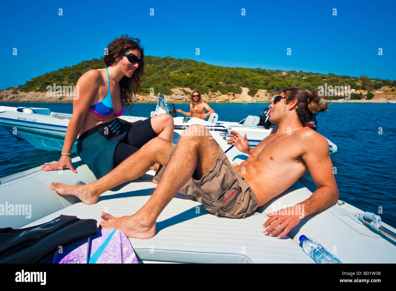 Fille et l'homme sur la proue d'un bateau gonflable en face d'une île Banque D'Images