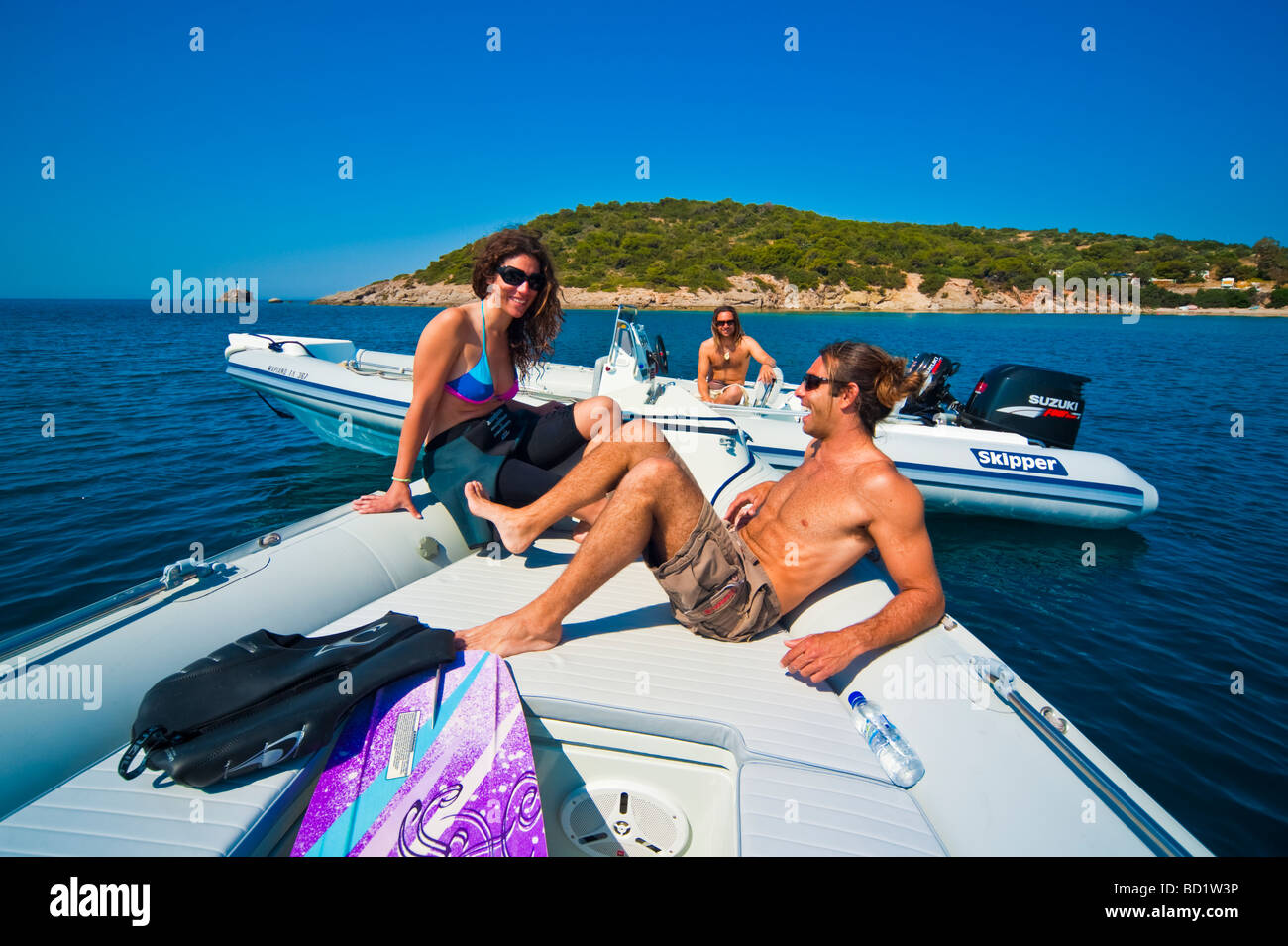 Fille et l'homme sur la proue d'un bateau gonflable en face d'une île Banque D'Images