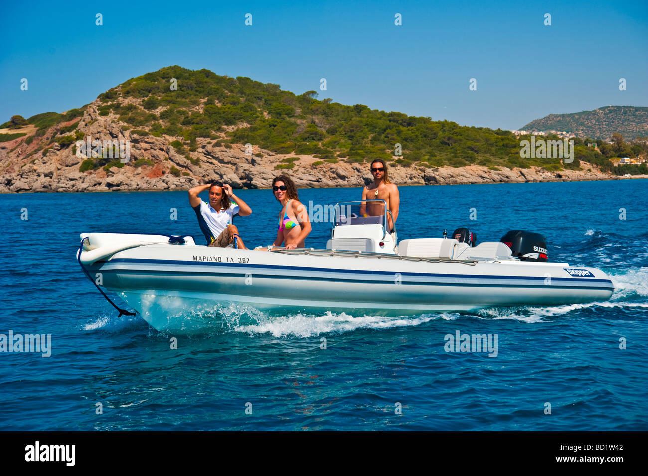 Fille avec deux hommes dans un bateau gonflable Banque D'Images