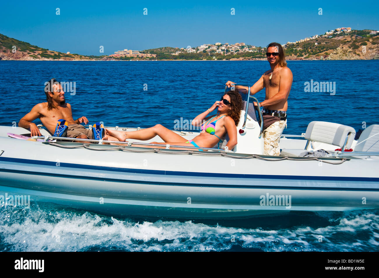 Fille avec deux hommes dans un bateau gonflable Banque D'Images