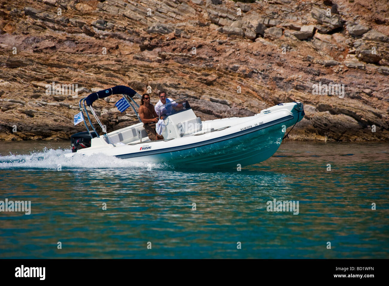 Les hommes en blanc rapide bateau gonflable à proximité du littoral Banque D'Images