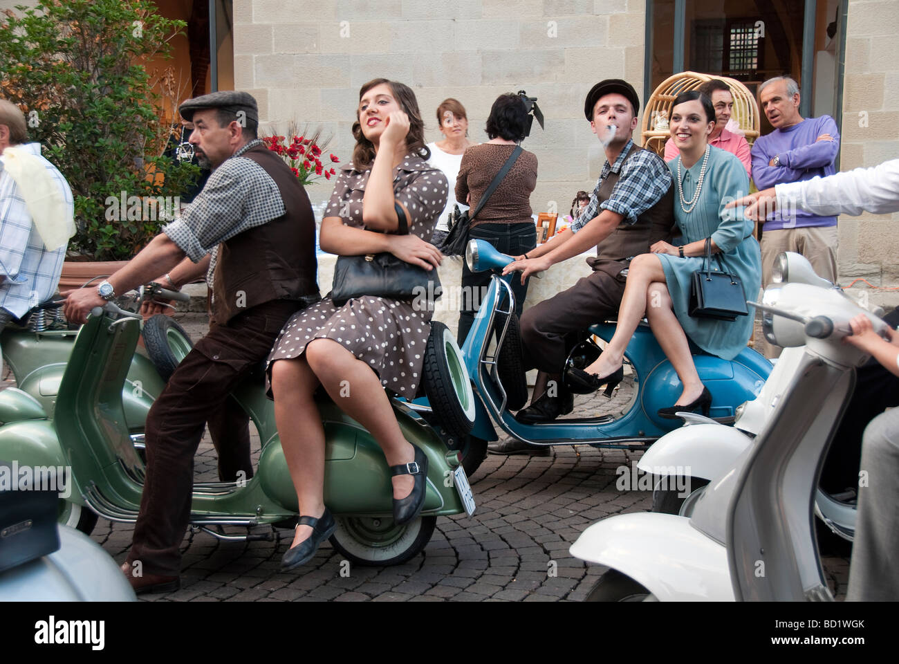 Les jeunes Italiens en costume des années 40 et 50 à cheval sur les scooters Vespa vintage à Sansepolcro Banque D'Images