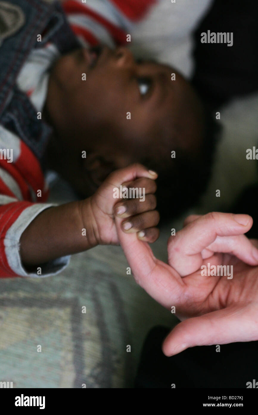 Un Bebe Noir Tenant Le Doigt D Une Femme Blanche Photo Stock Alamy