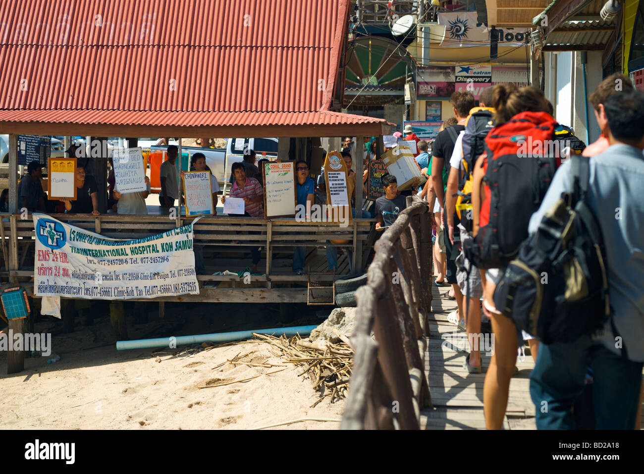 Les touristes laissant le ferry à port de Mae Haad sur Koh Tao avec l'attente de colporteurs à grande entre eux. Banque D'Images